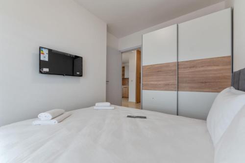 a bedroom with a bed with a tv on the wall at Cozy apartment in Čajetina