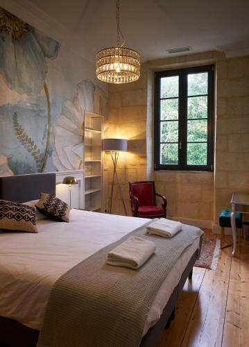 une chambre avec un grand lit avec deux serviettes dessus dans l'établissement Château Belvédère - Swimming pool, Vineyard & countryside, à Périssac