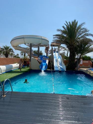 une piscine avec un toboggan aquatique dans un complexe hôtelier dans l'établissement Mobil-Home 1702, à Canet