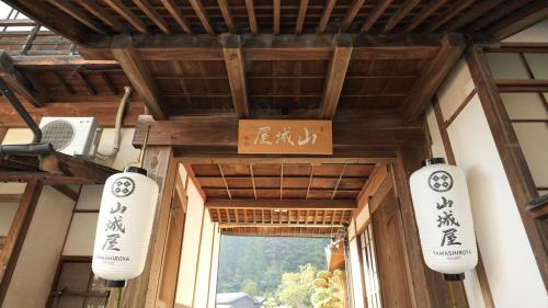two white lanterns hanging from the ceiling of a building at 山城屋リゾート in Aoki