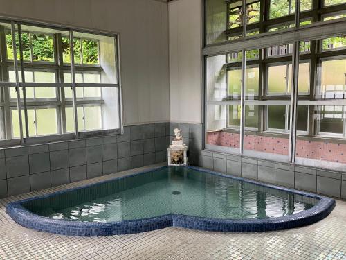 a swimming pool in front of a building with windows at 山城屋リゾート in Aoki