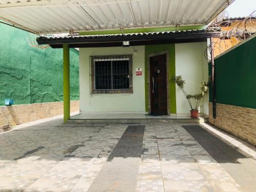 a building with a green wall and a door at Casa Spar do Atlântico com Piscina in Maricá