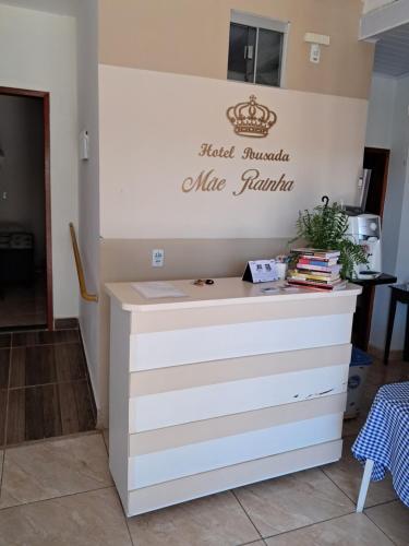 a counter in a kitchen with a sign on the wall at Hotel Pousada Mãe Rainha in Trindade