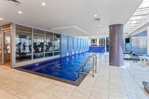 a swimming pool in a building with a gym at Belle Escapes - Bay View Lookout With Sea Views in Glenelg