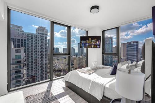 a bedroom with a white bed and large windows at Experience Miami Modern 2 Bed Near Biscayne Blvd in Miami