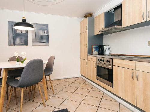 a kitchen with wooden cabinets and a table and chairs at 2 person holiday home in Højer in Højer