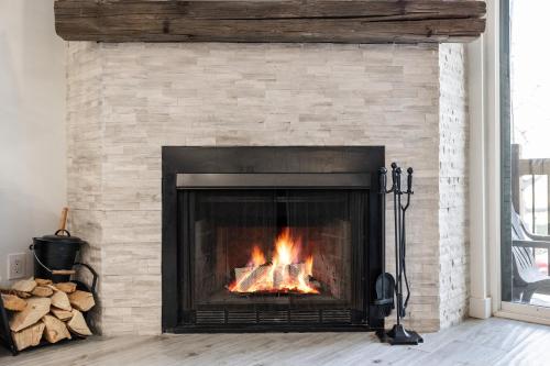 a brick fireplace with a fire in it at Walk to Main Street and Ski Lifts, Amazing Views, Community Hot Tub! in Park City