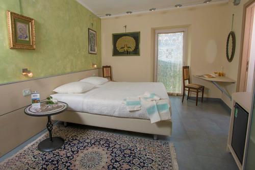 a bedroom with a bed and a table and a window at Villa Paggi Country House in Carasco