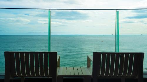 two benches sitting in front of a view of the ocean at H avenue Songjeong in Busan