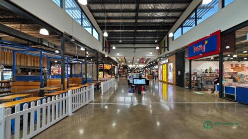 an aisle of a grocery store with people walking through it at Modern 2-Bedroom Townhouse Near DFO & RMIT in Bundoora
