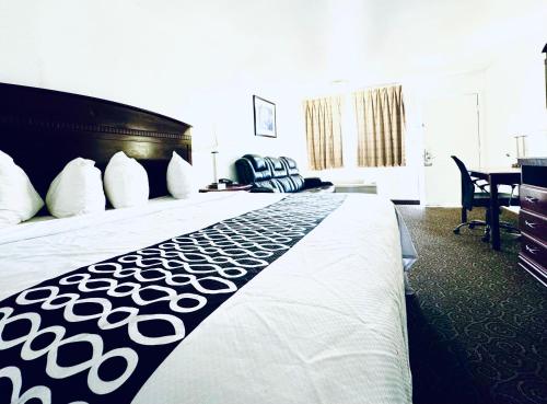 a hotel room with a large bed and a desk at Shiloh Inn Lamesa in Lamesa