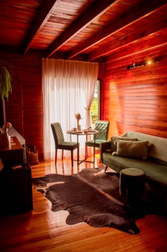 a living room with a couch and a table at Capanna del Vale - Refúgio & Degustação no Vale dos Vinhedos in Bento Gonçalves