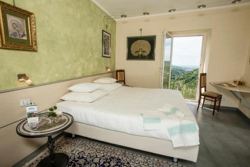 a bedroom with a bed with a table and a window at Villa Paggi Country House in Carasco