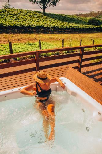 a person in a hot tub in a field at Capanna del Vale - Refúgio & Degustação no Vale dos Vinhedos in Bento Gonçalves
