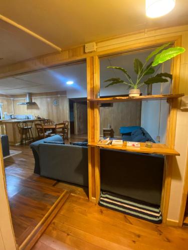 a living room with a couch and a plant on a shelf at Departamento la espiga in Chaitén