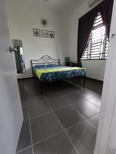 a bedroom with a bed and a tiled floor at Homestay faleeq in Jerantut