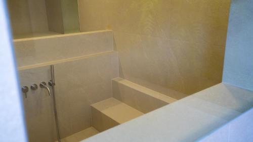 a bathroom with a shower with shelves in it at H avenue Songjeong in Busan