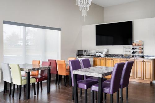 een eetkamer met een tafel, stoelen en een tv bij Baymont Inn & Suites in Liberty
