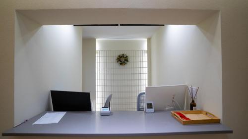 an office with a desk and a clock on the wall at H avenue Songjeong in Busan