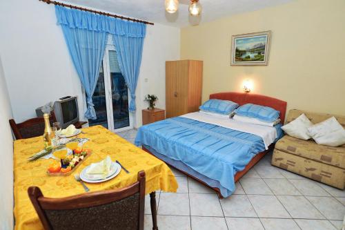 ein Schlafzimmer mit einem Bett, einem Tisch und einer Couch in der Unterkunft Apartments Marina in Sukošan