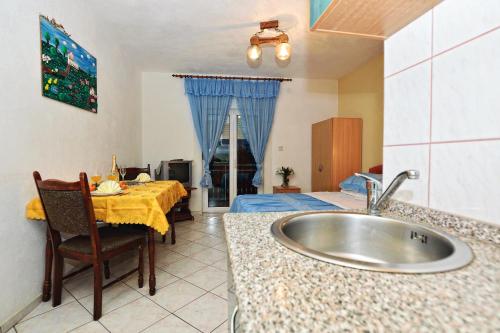 eine Küche mit einem Waschbecken und ein Schlafzimmer mit einem Bett in der Unterkunft Apartments Marina in Sukošan