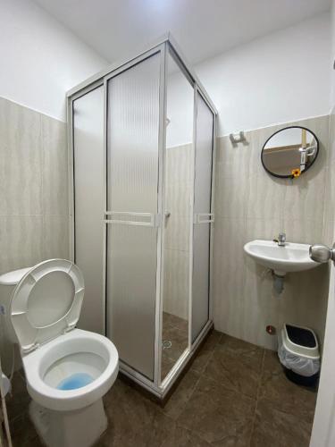 a bathroom with a shower and a toilet and a sink at hostal los cascabeles de la sierra in Santa Marta