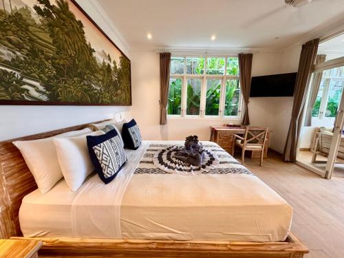 a bedroom with a large bed with a teddy bear on it at Suara Jiwa Luxury Villas with Private Pool in Ubud