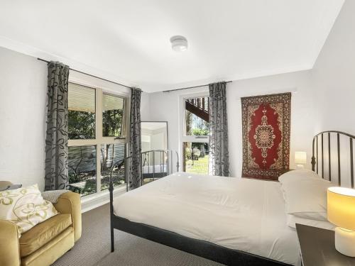 a bedroom with a bed and a couch and a window at Riverside 3-Bed Townhouse with Spacious Deck & BBQ in Mossy Point
