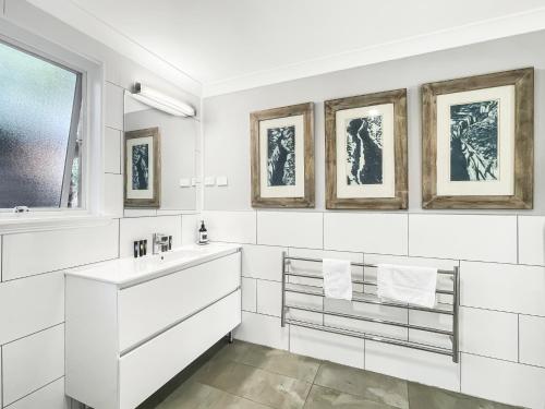 a white bathroom with a sink and a mirror at Riverside 3-Bed Townhouse with Spacious Deck & BBQ in Mossy Point