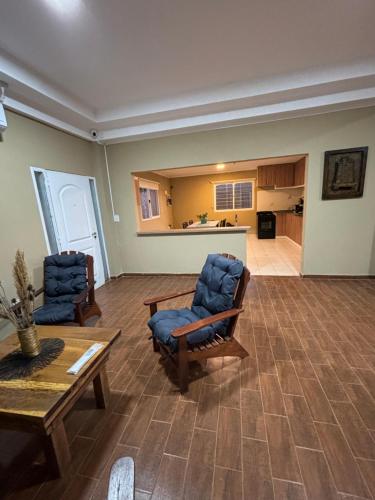 a living room with two chairs and a table at Casa Barrio del Lago in Garupá