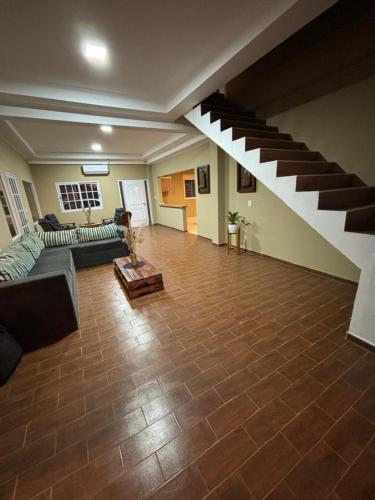 a living room with a staircase and a couch at Casa Barrio del Lago in Garupá