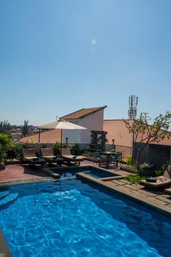 a swimming pool with chairs and an umbrella at SIEM REAP RIVER VIEW Residence in Siem Reap