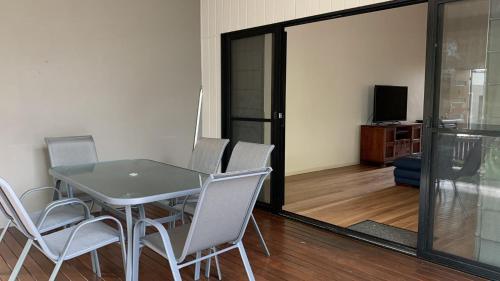 a dining room with a table and white chairs at Hook Wine Sinker in Brunswick Heads