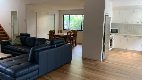a living room with a couch and a kitchen at Hook Wine Sinker in Brunswick Heads