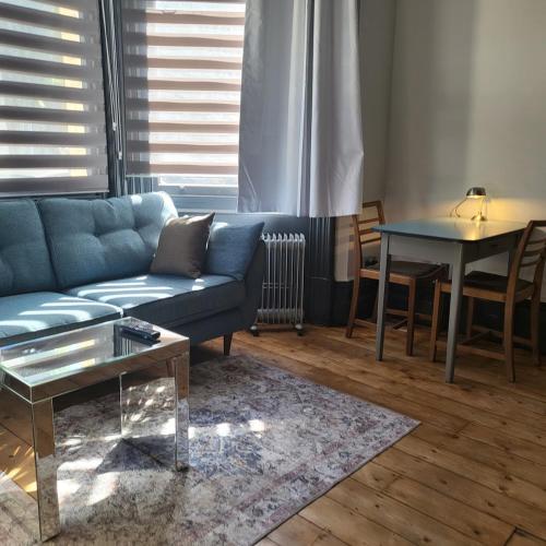a living room with a blue couch and a table at 21 Mini Loft - Prime Location - Hove - Quiet in Brighton & Hove
