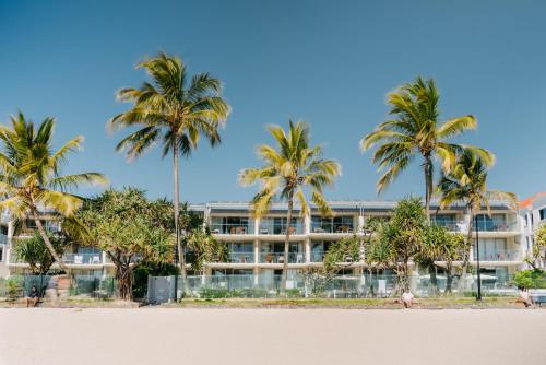 a hotel on the beach with palm trees at Fairshore in Noosa Heads