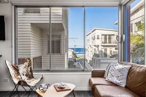 a living room with a couch and a large window at Daybreak Loft in Gold Coast