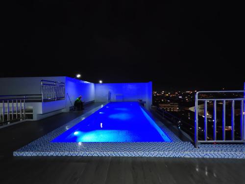 a swimming pool on the roof of a building at night at JD Haven Bachelor's Pad at Bernwood Tower in Iloilo City
