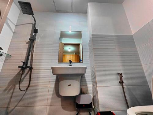 a bathroom with a sink and a toilet and a mirror at JD Haven Bachelor's Pad at Bernwood Tower in Iloilo City