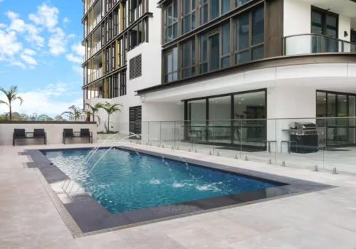 a swimming pool in front of a building at Stylish 2BR Apt with Pool & Views Near Parramatta in Sydney