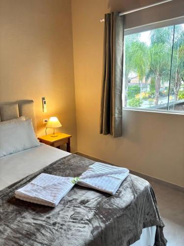 a bedroom with a bed with two towels on it at Pousada Maré Mansa in Paraty
