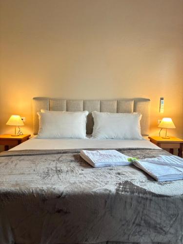 a bedroom with a bed with two tables and two lamps at Pousada Maré Mansa in Paraty