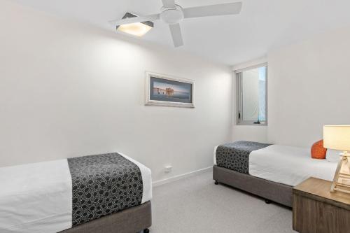 a bedroom with two beds and a window at Fairshore in Noosa Heads