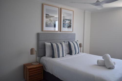 a bedroom with a large white bed with two pillows at Northwind Beachfront Apartments in Mooloolaba