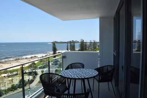 a balcony with a table and chairs and the ocean at Northwind Beachfront Apartments in Mooloolaba