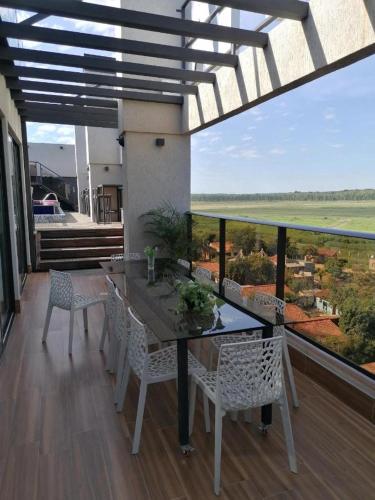 Presidente StroessnerにあるHotel Zetta Villageの家のバルコニーにダイニングテーブルと椅子