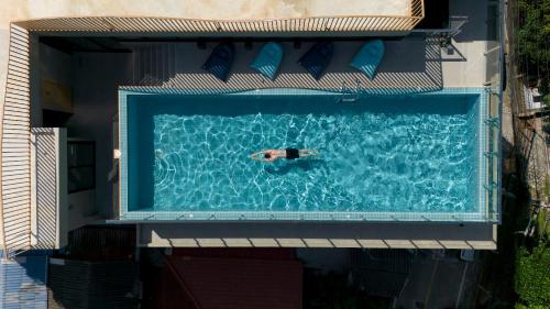 a man swimming in a swimming pool at P-Park Hotel Pattaya in Pattaya North