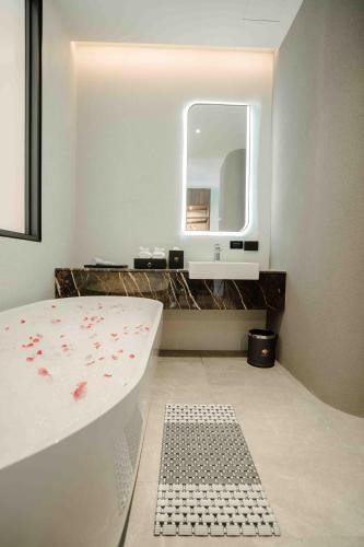 a bathroom with a bath tub and a mirror at Richmann Resort Hotel Hatyai in Hat Yai