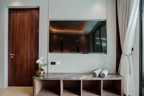 a room with a table with a mirror and a door at Richmann Resort Hotel Hatyai in Hat Yai