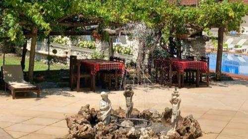 a fire hydrant in a courtyard with a fountain at Парк - Хотел Макензен in Melnik
